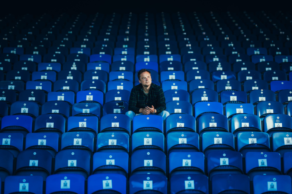 Illustrasjonsbilde Svendsens Catering Bartek Kaminski sitter i tribune